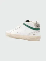 Zapatillas urbanas Golden Goose modelo Mid Star, de cuero color blanco con detalles en verde y estrella plateada. Suela con efecto envejecido.