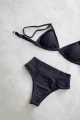 Conjunto de bikini de dos piezas con efecto brillante y estampado tipo tie-dye en tonos azules. El top es de estilo triángulo con breteles regulables y cierre de gancho en la espalda. La bombacha es de tiro alto y corte vedetina.