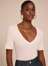 Remera blanca de tejido de punto con corte ajustado, escote en V, mangas cortas y acabado pespunteado.