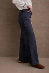 Pantalón de vestir azul marino de corte recto y tiro alto, con detalle de volados en la cintura y cierre frontal.