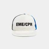 Gorro tipo gorra de béisbol de Eme Studios, modelo Due Shadow, color blanco con paneles laterales en azul y negro, y detalles en rojo. Presenta la inscripción "EME/CPH" bordada en negro en la parte frontal.