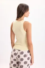 Musculosa de punto a la base, color amarillo, con cuello redondo y diseño ajustado.