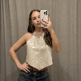 Top halter de cuero plateado con acabado metalizado, diseño estructurado con costura central vertical y bajo en punta.