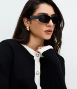Cardigan de punto color blanco con detalles en negro en cuello, puños y tapeta frontal. Presenta cierre frontal con botones perlados y dos bolsillos delanteros falsos con solapa bicolor.