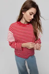 Remera de manga corta con diseño a rayas horizontales azules y blancas, corte relajado y cuello redondo.