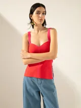 Top rojo de punto jacquard, corte ajustado, con breteles fucsia, tajos laterales y cierre en la espalda.