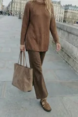 Sweater de tejido de punto acanalado en color marrón, con cuello redondo, mangas largas y aberturas laterales en el ruedo.