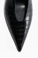 Zapato destalonado negro con textura de cocodrilo, punta fina y taco bajo/medio de forma curva. Posee una tira elástica en el talón para ajuste.