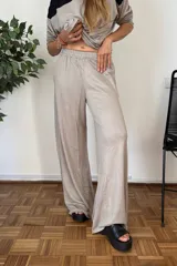 Pantalón de tejido jersey color beige oscuro, de corte muy amplio y pierna ancha, con cintura elástica.