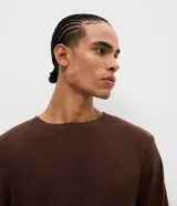 Pijama masculino de dos piezas confeccionado en tejido fleece texturizado. Incluye una remera de manga larga con cuello redondo y puños ajustados, y un pantalón tipo jogger con cintura elástica, cordón de ajuste y bolsillos laterales.