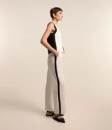 Pantalón de vestir blanco de crepé, corte recto, con trabillas en la cintura, bolsillos laterales y raya lateral negra.