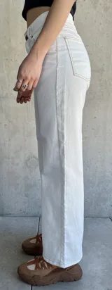 Pantalón jean de tiro alto color blanco, corte recto y pierna ancha.