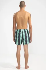 Short de baño negro con estampado de flores verdes y celestes, cintura elástica con cordón regulable, bolsillos laterales y trasero con cierre, suspensor de malla fina hipoalergénico.