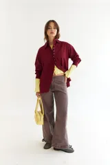 Camisa de algodón color bordó, con cuello clásico, cierre frontal de botones y diseño con recorte diagonal en el frente y aberturas laterales. Presenta un bordado en zigzag en la espalda.