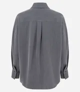 Camisa de corte oversized con estilo sastre, confeccionada en tejido plano. Presenta cuello clásico, cierre frontal con botones, mangas largas con puños anchos y sisas desplazadas.
