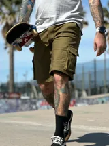 Bermuda cargo color verde militar con bolsillos laterales con solapa, corte recto y largo hasta la rodilla.