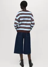 Sweater de punto fino con diseño oversize y estampado de rayas horizontales en tonos marrón, celeste y blanco. Presenta cuello redondo y mangas largas.