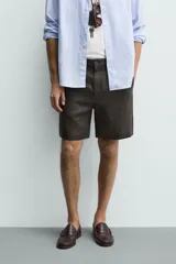 Bermuda regular fit azul marino confeccionada en lino, con bolsillos frontales, bolsillos traseros de doble vivo con botón y cierre frontal con cremallera y botón.