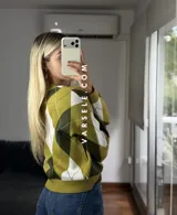 Sweater de tejido de punto con diseño de rombos en tonos verde oliva, verde oscuro y blanco. Presenta cuello redondo, mangas largas con puños acanalados y un corte holgado.