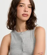 Musculosa de tejido rib con cuello redondo y cierre frontal con botones. Diseño sin mangas y ajuste al cuerpo.