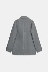 Blazer de corte recto y diseño minimalista, confeccionado en tejido de paño suave color beige. Presenta cuello con solapas clásicas, cierre frontal con un solo botón y dos bolsillos delanteros con solapa.
