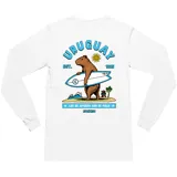 Remera de manga larga color blanco, con estampado gráfico en la espalda que muestra un carpincho con una tabla de surf, el sol de mayo y la leyenda 'Uruguay Est. 1825'.