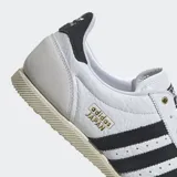 Championes Adidas Japan blancos con detalles en negro y beige. Diseño de cuero perforado con las tres tiras características de Adidas en los laterales.