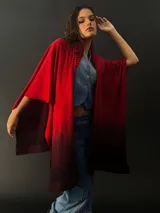 Ruana larga de lana merino color gris con cuello plisado de fieltro. Diseño degradado con terminación en flecos.