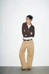 Chaqueta de felpa negra con cuello solapa, manga larga con puño, bolsillos de plastrón en el delantero y cierre frontal con cremallera.