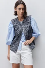 Short de jean blanco de tiro alto, con calce recto, silueta relajada y diseño de cinco bolsillos. Presenta cierre frontal con botón y cremallera, presillas para cinturón y terminación con ruedo desflecado.