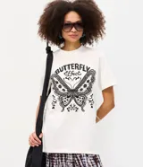 Remera de algodón color blanco, de corte holgado y manga corta, con cuello redondo y estampa frontal en negro con la inscripción "Butterfly Effect" y un diseño de mariposa.