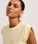 Blusa de manga corta, cuello redondo y corte ajustado, confeccionada en tejido rib de algodón.