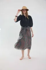 Camisa de lino color beige, de silueta romántica con escote a la base y mini volado. Cuenta con mangas 3/4 abullonadas con frunces y terminación en elástico. Posee detalles de puntillas negras en contraste en el frente y cierre frontal con botones ocultos bajo cartera.