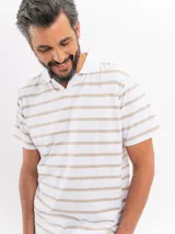 Remera de manga corta con diseño a rayas horizontales en color blanco y beige, cuello polo con escote en V y calce relajado.