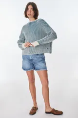 Sweater de punto a rayas verticales blancas y negras, con cuello redondo y mangas largas.