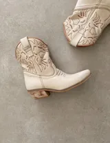 Bota corta estilo western de cuero color marrón, con taco cuadrado de 5 cm y diseño clásico. Presenta un acabado desgastado en la puntera y el talón.