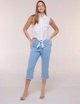 Capri de denim celeste claro, de tiro alto con pretina elástica ancha, bolsillos falsos al frente y ruedo desflecado con largo por debajo de la rodilla.