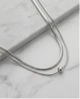Collar doble de acero con cadenas tipo serpiente y dije central esférico pasante.