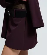 Short pollera de estilo sastre con diseño estructurado, cintura con trabillas y cinturón desmontable con hebilla metálica.