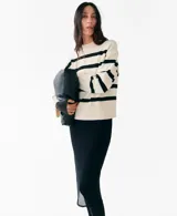 Chaleco oversize de punto con diseño a rayas horizontales en color crudo y negro, cuello redondo y mangas sisa con amplios ribetes elásticos.