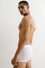 Pack de tres calzoncillos tipo trunk cortos de color blanco, confeccionados en tejido elástico con costuras planas, cintura elástica y parte delantera forrada.