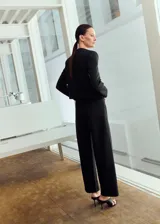 Pantalón de vestir negro de corte recto y tiro alto, con diseño sastre y perneras amplias.