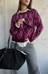Sweater de tejido de punto con diseño de rombos en tonos bordó y magenta, con cuello redondo y terminaciones en color crema.