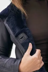 Campera de cuero tipo lambskin con diseño de paneles, cuello con solapas de piel sintética, cierre frontal con botones y bolsillos laterales.