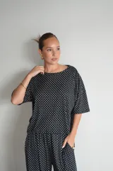 Pantalón negro de algodón y viscosa, con estampado de lunares blancos y corte holgado.