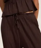 Pantalón recto de tiro medio, confeccionado en viscosa texturizada color bordó. Presenta cintura elástica con lazo ajustable y diseño de pierna recta y fluida.