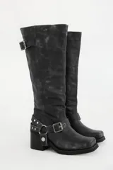 Bota bucanera de cuero color negro, con punta cuadrada, taco ancho y estribo desmontable con hebillas y tachas.