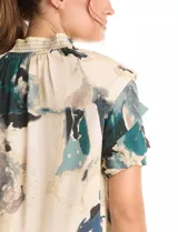 Blusa de gasa con estampado abstracto en tonos beige, azul y verde. Presenta cuello mao fruncido con lazos ajustables, escote en V y mangas cortas con volados y puños elásticos.