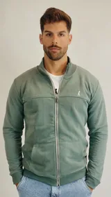 Campera de algodón color verde, con cierre frontal completo, cuello alto tipo bomber y bolsillos laterales tipo canguro.