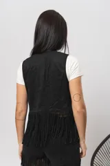Chaleco marrón de gamuza con flecos y tachas plateadas.